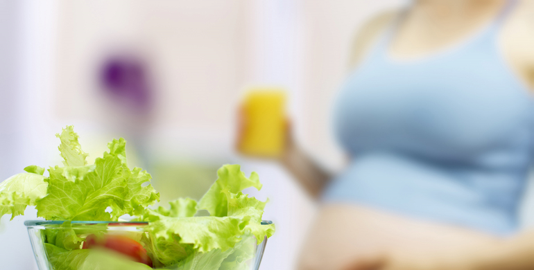 Femme enceinte qui s'apprete à manger des crudités